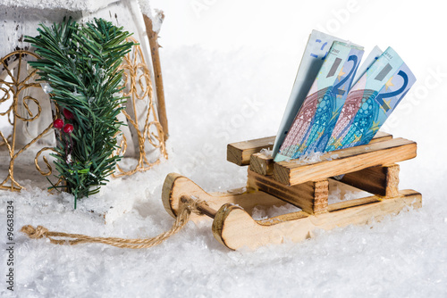 Sledge on snow with money on winter vacation