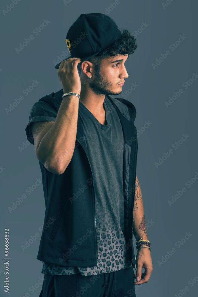Tough young man in dark t-shirt on grey background Tough young man in dark t-shirt on grey background