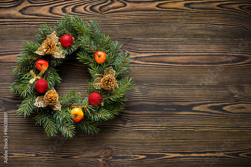 Christmas wreath on brown wooden table top view