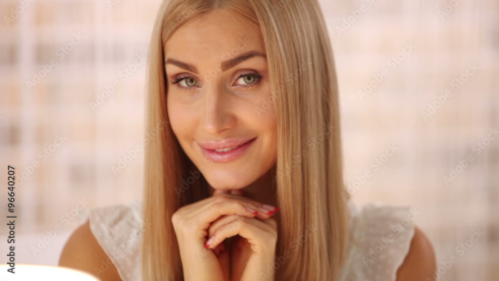 Cute young woman sitting at cafe with cup of tea looking at camera and smiling. Panning camera Cute young woman sitting at cafe with cup of tea looking at camera and smiling. Panning camera