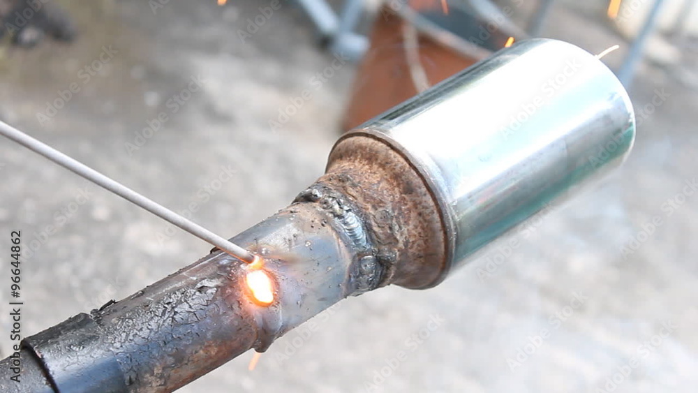Technician is welding the exhaust pipe. Manufacturing and modify