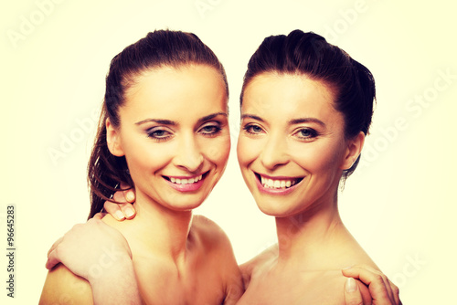 Two sisters with make up embracing.