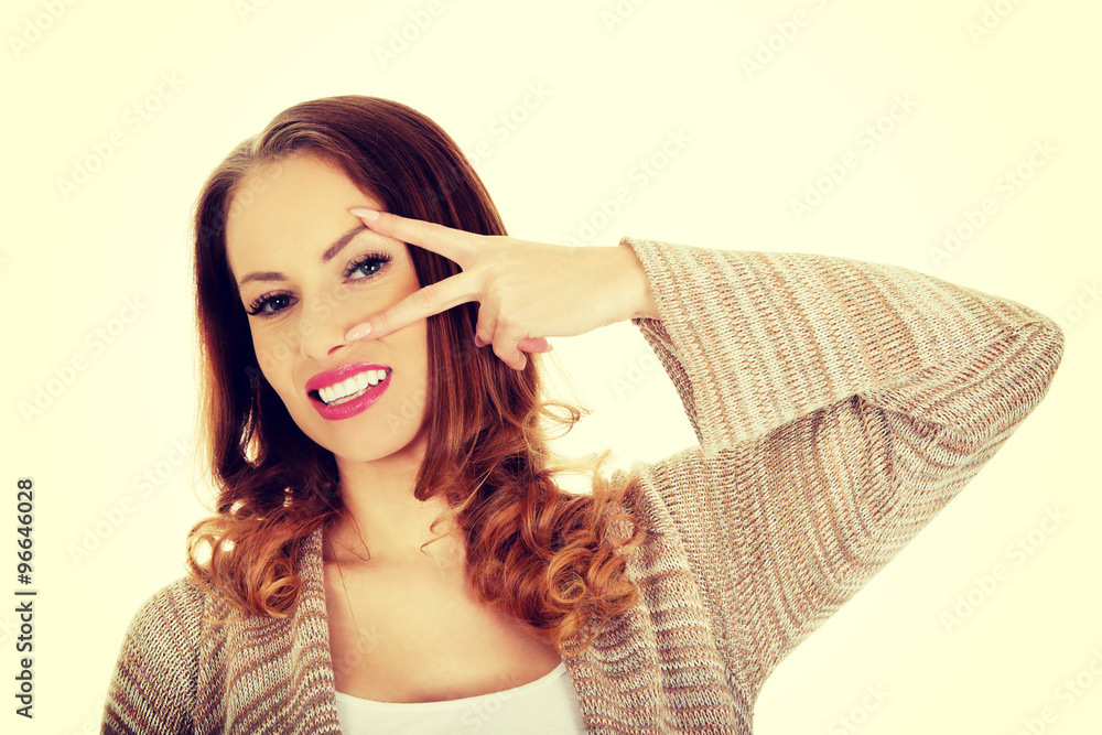 Young woman showing peace gesture.