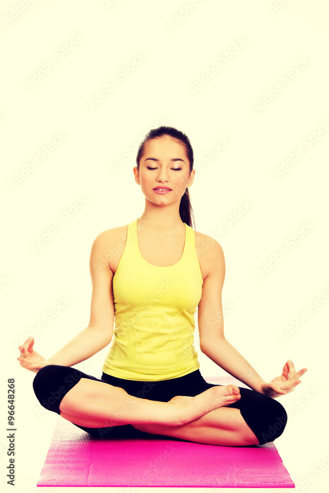 Slim female meditating in pose of lotus.