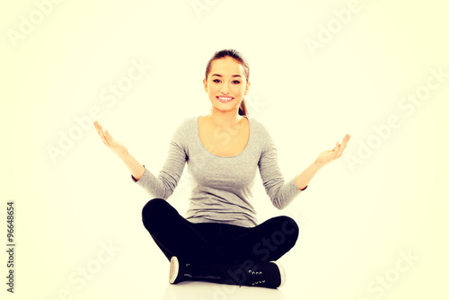 Woman sitting cross legged with open hands. © Piotr Marcinski