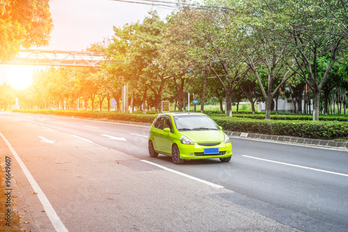 green car driving on the road