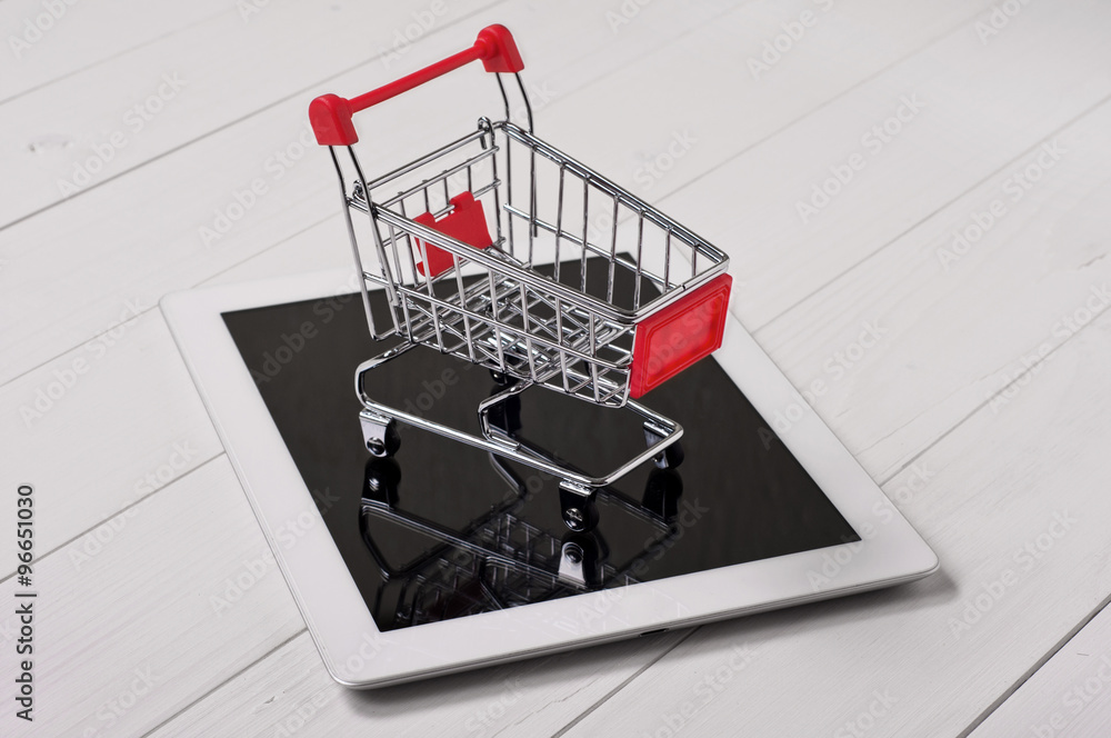 Small shopping cart on a white tablet computer