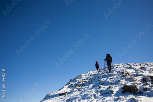 Mountaineers climb the snowy slope.