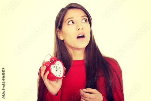 Shocked woman with alarm clock.