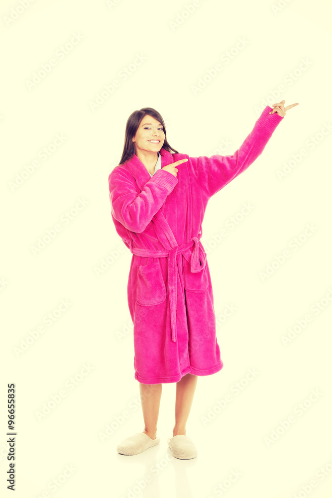 Woman in pink bathrobe pointing aside. Woman in pink bathrobe pointing aside.
