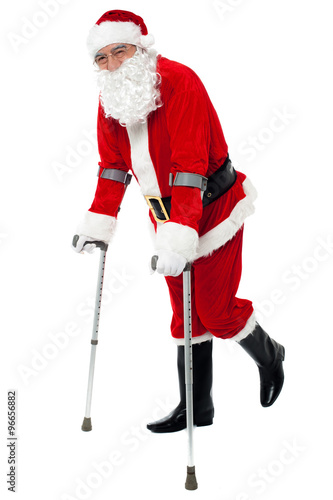 Injured santa walking with help of crutches