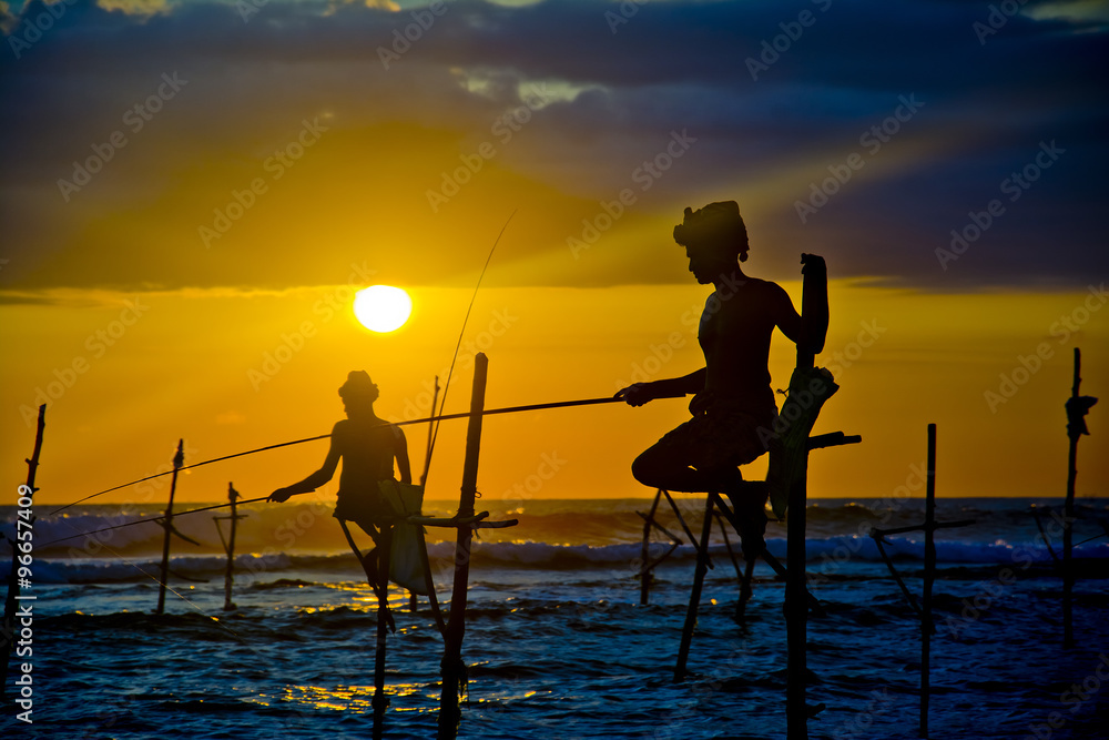 Silhouettes of the traditional fishermen at the sunset near Galle in Sri Lanka.