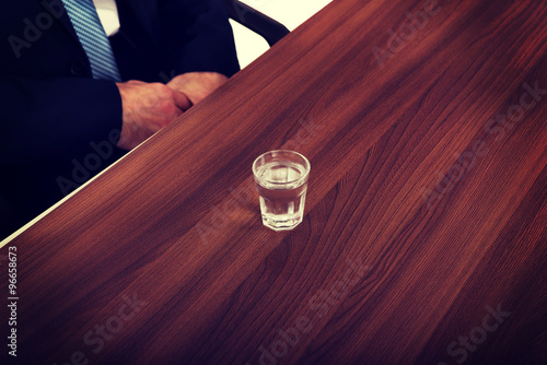 Glass of clear vodka on the desk photo