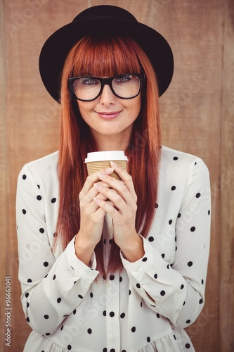 Smiling hipster woman drinking coffee