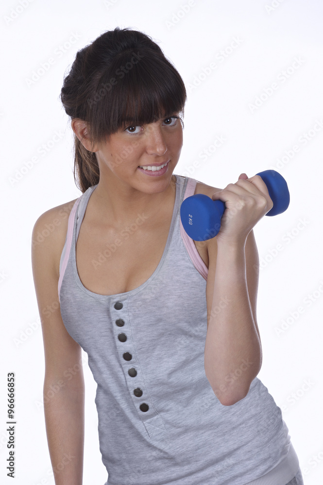Teenager doing physical exercise with dumbbells Teenager doing physical exercise with dumbbells