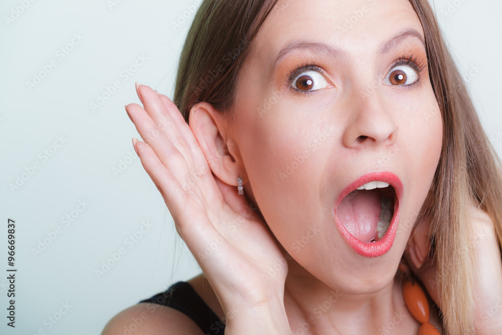 Shocked gossip girl eavesdropping with hand to ear. Shocked gossip girl eavesdropping with hand to ear.