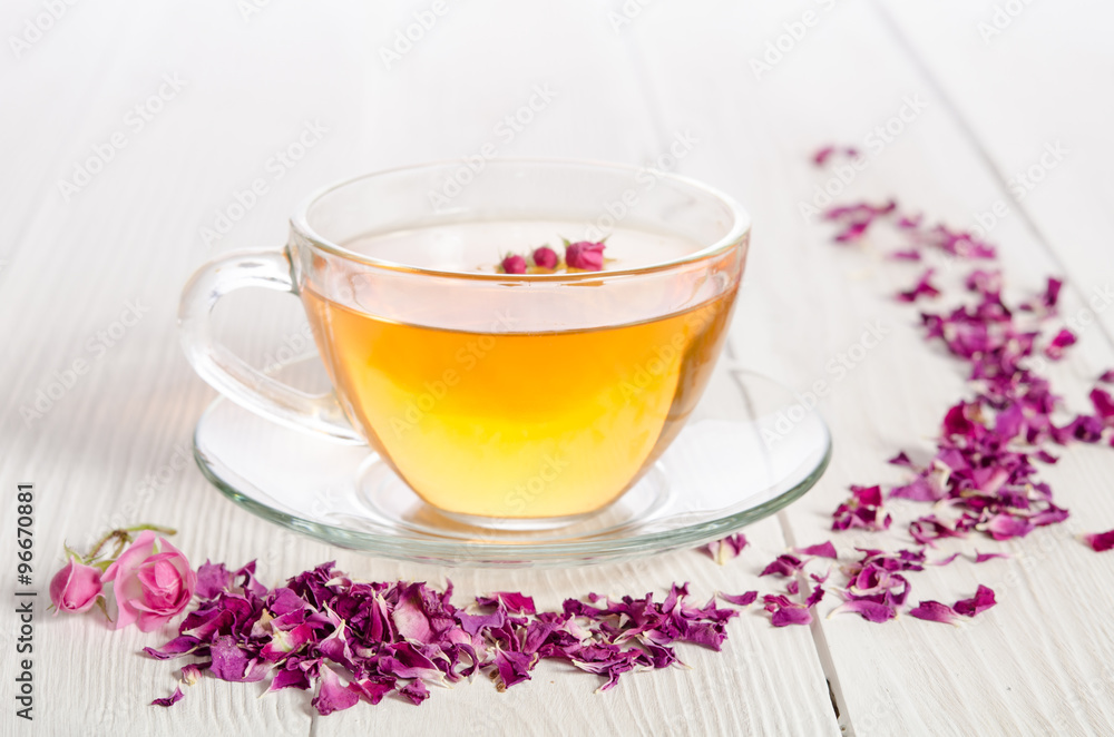 Rose tea and dried petals on white wooden table Rose tea and dried petals on white wooden table