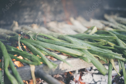 a pile of calçots, typical catalan sweet onions, on the barbecu photo
