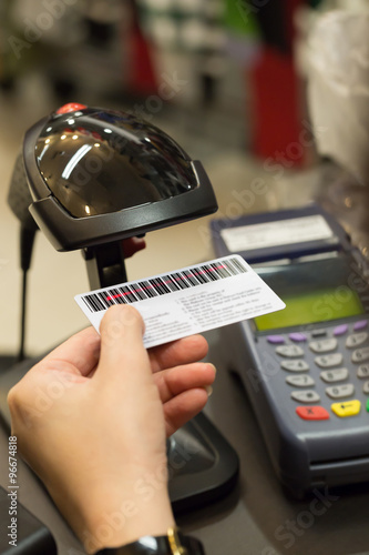 Cashier's hand scanning barcode on member card with credit card