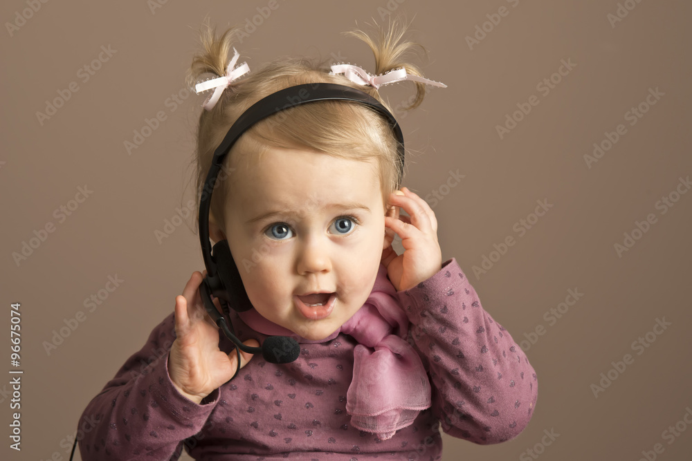Baby girl talking on a headphones Baby girl talking on a headphones