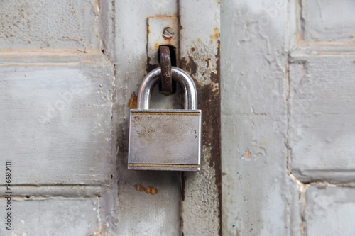 Old lock on wooden grungy painted door closeup.