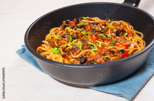 spaghetti with vegetables and minced meat in a frying pan