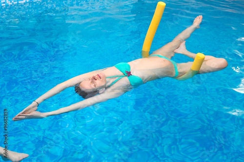 Water Yoga/ a pregnant woman does her yoga exercises at the pool