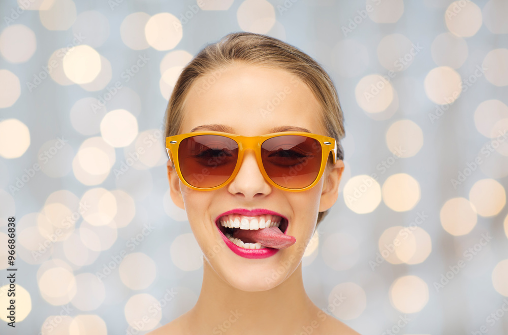 happy young woman in sunglasses showing tongue happy young woman in sunglasses showing tongue