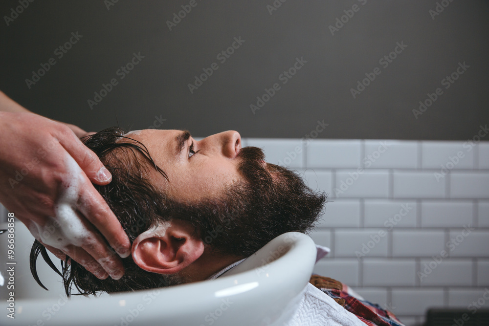 Fotografie Barber washing client's hair