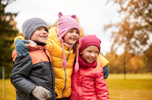 group of happy children hugging in autumn park