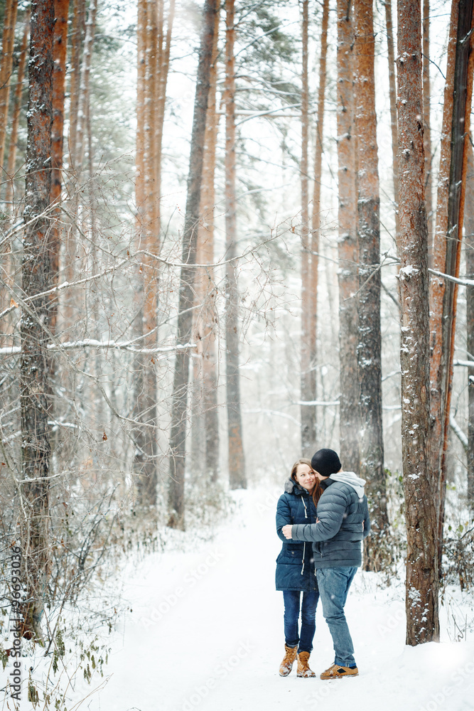 Young Couple Embracing in Winter Forest