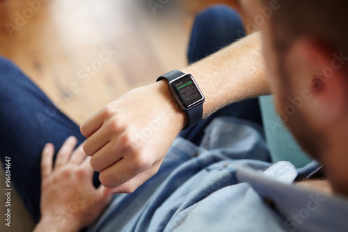 Man Looking At News Application Software On Smart Watch