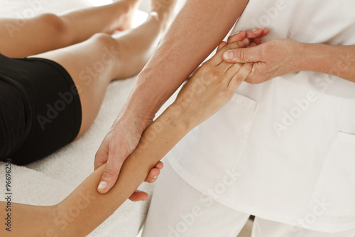 Terapeuta profesional dando masaje en un brazo, en la muñeca y en la mano. Vista supeior y de cerca photo