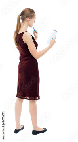 back view of  stands woman takes notes in a notebook. girl  watc