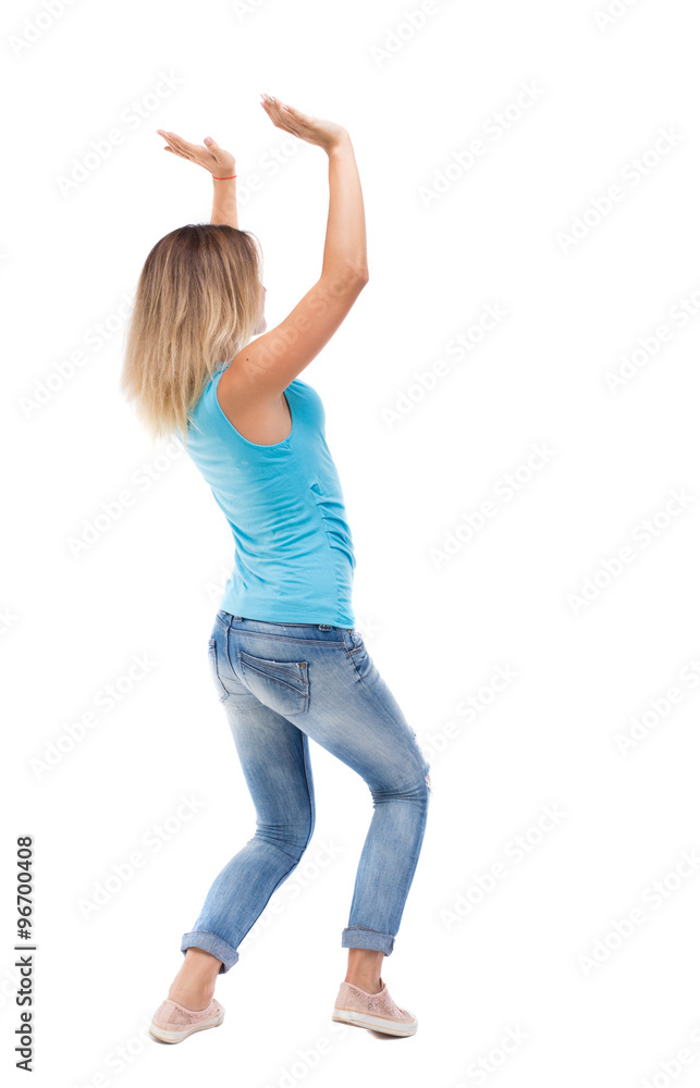 back view of woman protects hands from what is falling from abo back view of woman protects hands from what is falling from abo
