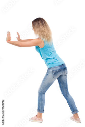 back view of woman pushes wall.