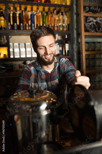 Man barista preparing coffee for his customers while laughing