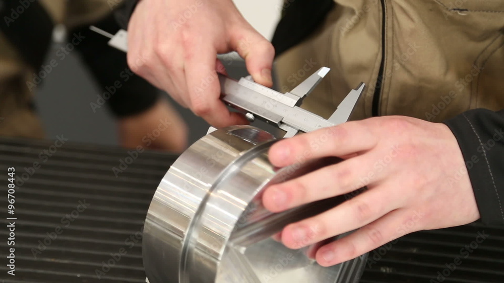 The hand of the worker is measured by a calliper metal product The hand of the worker is measured by a calliper metal product