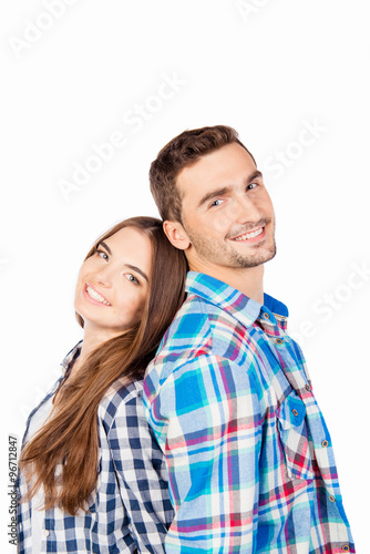 Happy couple in love holding hands standing back to back