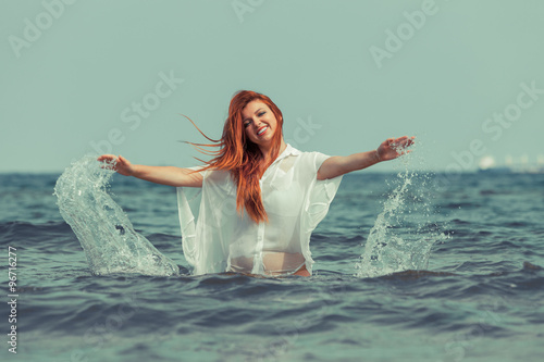 Girl splashing water on the coast.