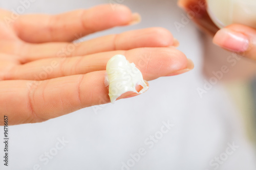 Skin care. Moisturizing cream on female finger