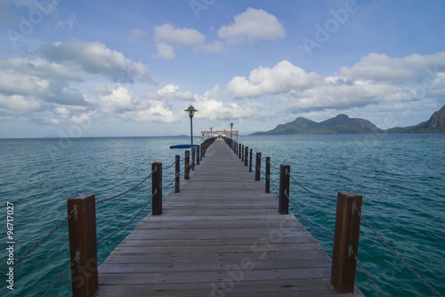 Long wooden pier heading toward Bohey Dulang Island in Sabah Borneo Malaysia.