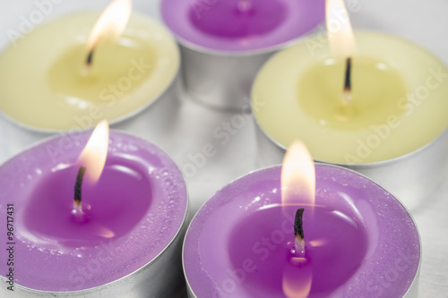 Scented candles with lilac fragrance in front of others with green apple fragrance
