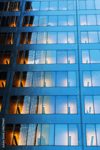 Fassadendetail eines Bürohochhauses mit beleuchteten Fenstern