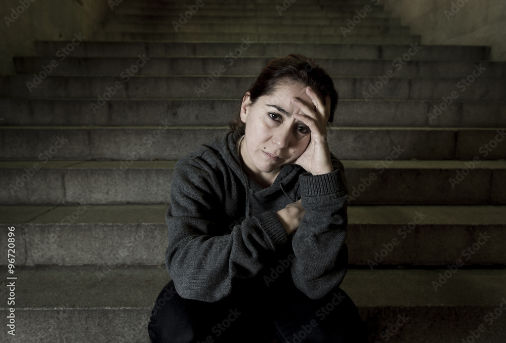 Obraz premium sad woman alone on street subway staircase suffering depression looking looking sick and helpless