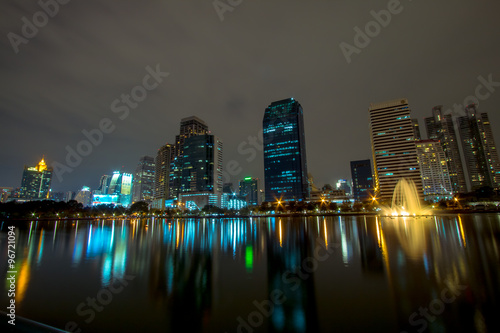 Golden lake and Night view of building, Business centre in Asoke area in Bangkok, the reflection of golden light Building at lake in benja kitti prak, Thailand. photo