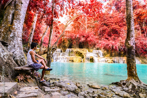 Bilde på lerret Man waiting for someone at rainforest waterfall, Tat Kuang Si Waterfall at Luang Prabang, Loas
