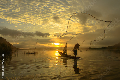 silhouette fisherman of Bangpra Lake in action when fishing, Tha photo