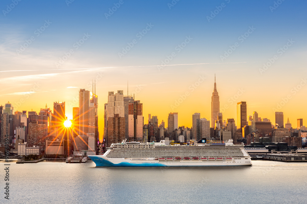 Naklejka premium Panoramę Nowego Jorku o wschodzie słońca, patrząc z Weehawken, wzdłuż 42 kanionu ulicy. Duży statek wycieczkowy płynie rzeką Hudson, a promienie słońca pękają między wieżowcami.