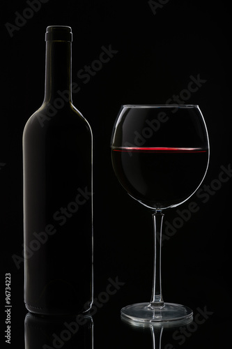 Glass of red wine and bottle